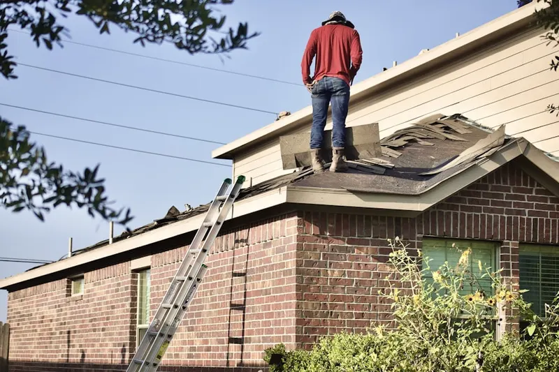 Professional roofer working on a residential roof in Plumville